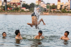 Trước thời tiết nắng nóng kỷ lục ở Hà Nội, người dân đã tận dụng hồ Linh Đàm làm nơi 'giải nhiệt' vì tiện lợi, nhanh chóng và không mất chi phí nào. (Ảnh: Minh Sơn/Vietnam+)