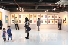 Có rất nhiều người yêu nghệ thuật đi cùng gia đình đến để xem tranh. (Ảnh: PV/Vietnam+)