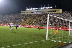 Tình huống đáng chú ý trong trận đấu giữa CLB Nam Định (áo trắng) và CLB Sài Gòn (áo đỏ). (Ảnh: Công Luật/TTXVN)