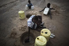 Người dân cố gắng múc nước từ đáy sông khô cạn ở Turkana, Kenya. (Ảnh: AFP/TTXVN)