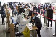 Nhân viên y tế lấy mẫu xét nghiệm COVID-19 cho người dân tại Bắc Kinh, Trung Quốc. (Ảnh: Kyodo/TTXVN)