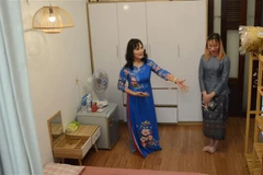 Người dân giới thiệu về phòng ngủ đã chuẩn bị cho sinh viên Lào. (Ảnh: Văn Dũng/TTXVN)