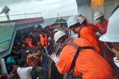 Đưa các công dân Sri Lanka từ tàu cá Lady R3 lên tàu Helios Leader. (Ảnh: TTXVN phát)