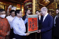 Thủ tướng Phạm Minh Chính tặng Thủ tướng Đức Olaf Scholz bức thư pháp với nội dung "Hòa bình - Hữu nghị cùng phát triển" tại đền Ngọc Sơn. (Ảnh: An Đăng/TTXVN)