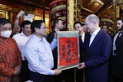 Thủ tướng Phạm Minh Chính tặng Thủ tướng Đức Olaf Scholz bức thư pháp với nội dung "Hòa bình - Hữu nghị cùng phát triển" tại đền Ngọc Sơn. (Ảnh: An Đăng/TTXVN)