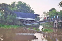 Nhịp giữa của cầu Xẻo Quýt lún sâu xuống nước. (Ảnh: TTXVN phát)