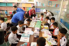 Học sinh trường tiểu học Nơ Trang Lơng đọc sách từ chương trình Tủ sách Đinh Hữu Dư trao tặng. (Ảnh: Hoài Thu/TTXVN)
