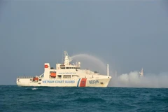 Tàu CSB 8004 thực hành phun nước dập cháy tàu bị nạn trong luyện tập phối hợp tìm kiếm cứu nạn. (Ảnh: TTXVN phát)