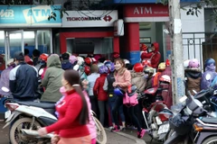 Người dân xếp hàng chờ rút tiền tại cây ATM trên đường Hòa Lạc. (Ảnh: Ngọc Hà: TTXVN)