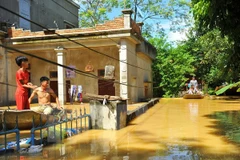 Nước ngập sâu nên người dân tại thôn Kiến Phong, xã Gia Tường, huyện Nho Quan, Ninh Bình phải di chuyển bằng thuyền. (Ảnh: Minh Đức/TTXVN)