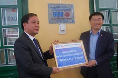 Ông Phạm Quang Tùng (trái) tại lễ bàn giao công trình nhà bán trú Trường THCS xã Nậm Khắt huyện Mù Cang Chải. (Nguồn: BIDV)