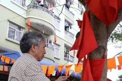 Treo cờ phướn trang trí tại khu vực bầu cử. (Ảnh: Trung Hiền/Vietnam+)