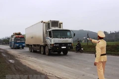 Cảnh sát giao thông tiến hành kiểm tra phương tiện lưu thông trên tuyến Quốc lộ 1. (Ảnh: TTXVN)