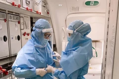 Việc mặc trang phục bảo hộ giúp ngăn chặn nguy cơ lây nhiễm COVID-19. (Ảnh: VNA cung cấp)