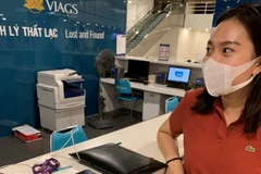 Hành khách nhận lại tài sản bỏ quên trên chuyến bay VN7210 Thành phố Hồ Chí Minh-Hà Nội. (Ảnh: CTV/Vietnam+)