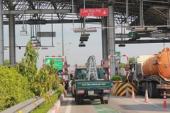 Phương tiện dán thẻ thu phí tự động đi vào làn đường của trạm thu phí được lắp đặt thu phí tự động. (Ảnh: Việt Hùng/Vietnam+)