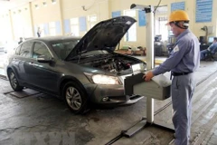Đăng kiểm viên tiến hành kiểm định phương tiện đến đăng kiểm. (Ảnh: Hoàng Hùng/TTXVN)