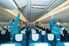 Nhân viên dịch vụ vệ sinh trên khoang khách của máy bay Vietnam Airlines. (Ảnh: CTV/Vietnam+)