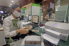 Khách hàng giao dịch tại hội sở chính Vietcombank, 198 Trần Quang Khải, Hà Nội. (Ảnh: Trần Việt/TTXVN)