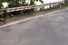 Đoạn xuất hiện vết rạn nứt vào đã được xây kè đá kiên cố nhưng vẫn xuất hiện các vết rạn nứt mới, gây nguy cơ sạt lở tuyến đường này. (Ảnh: Công Mạo/TTXVN)