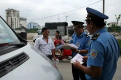 Kiểm tra giấy phép hoạt động của phương tiện vận tải. (Ảnh: Huy Hùng/TTXVN)