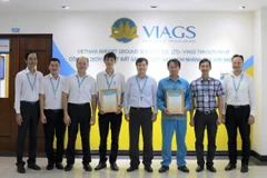 Anh Đường Khánh Tùng (thứ tư từ trái sang) và anh Trần Ngọc Kỳ (thứ ba từ phải sang) nhận thư biểu dương của Ban lãnh đạo Công ty Dịch vụ mặt đất sân bay Việt Nam. (Ảnh: CTV/Vietnam+)