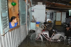 Triều cường dâng cao gây ngập nước trong nhà nhiều hộ dân tại các con hẻm trên đường Xô Viết Nghệ Tĩnh, phường 25, quận Bình Thạnh. (Ảnh: Mạnh Linh/TTXVN)