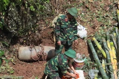 Các chiến sỹ công binh lắp đặt khối thuốc nổ để hủy nổ một quả bom ở Sơn La. (Ảnh: Lê Hữu Quyết/TTXVN)