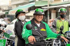 Tài xế Gojek chở khách bằng xe điện Selex. (Ảnh: PV/Vietnam+)