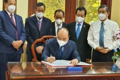 Chủ tịch nước Nguyễn Xuân Phúc viết cảm tưởng vào Sổ vàng tại Khu lưu niệm Chủ tịch Tôn Đức Thắng. (Ảnh: TTXVN phát)