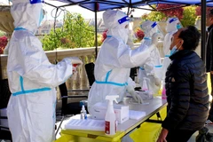 Nhân viên y tế lấy mẫu xét nghiệm COVID-19 cho người dân tại Thượng Hải, Trung Quốc, ngày 6/4/2022. (Ảnh: THX/TTXVN)