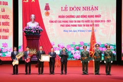 Thay mặt lãnh đạo Đảng, Nhà nước, Bí thư Thành ủy Hà Nội Đinh Tiến Dũng trao Huân chương Lao động hạng Nhất của Chủ tịch nước cho Đảng bộ và nhân dân huyện Đông Anh. (Ảnh: TTXVN phát)