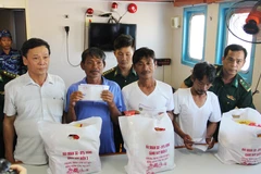 Đại diện địa phương Khánh Hòa trao quà hỗ trợ cho 4 ngư dân gặp nạn may mắn sống sót sau gần 10 ngày lênh đênh trên biển. (Ảnh: Phan Sáu/TTXVN)