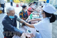 Bệnh nhân được bác sỹ khám sức khoẻ, đo huyết áp hậu COVID-19. (Ảnh: Thu Hương/TTXVN)