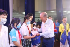 Nguyên Phó Thủ tướng Thường trực Chính phủ Trương Hòa Bình trao tăng quà, bánh trung thu cho các em thiếu nhi tại chương trình Trung thu yêu thương năm 2022 vào 11/9. (Ảnh: Thanh Vũ/TTXVN)
