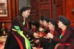 Liền chị quan họ Thị Cầu mời trầu tại canh hát quan họ. (Ảnh: Thái Hùng/TTXVN)