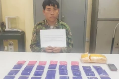 Đối tượng Vàng A Nhịa cùng tang vật tại cơ quan công an. (Ảnh: TTXVN phát) 