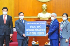 Chủ tịch Mặt trận Tổ quốc Việt Nam Đỗ Văn Chiến tiếp nhận tượng trưng số tiền ủng hộ phòng, chống dịch của cộng đồng người Việt tại Canada. (Ảnh: Minh Đức/TTXVN) 