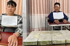 Hai đối tượng Vàng A Sồng (trái) và Hờ A Thu cùng 8 bánh heroin tại cơ quan điều tra. (Ảnh: TTXVN phát)