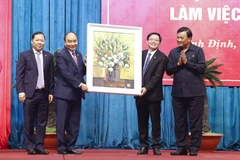 Chủ tịch nước Nguyễn Xuân Phúc tặng bức tranh lưu niệm cho tỉnh Bình Định. (Ảnh: Thống Nhất/TTXVN) 