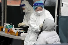 Nhân viên y tế lấy mẫu xét nghiệm COVID-19 cho một em nhỏ tại Seoul, Hàn Quốc ngày 16/2. (Ảnh: THX/TTXVN)