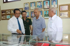 Ông Nguyễn Văn Được, Bí thư Tỉnh ủy, Chủ tịch Hội đồng Nhân dân tỉnh Long An cùng các đại biểu tham quan khu trưng bày kỷ vật, hình ảnh trong trận đánh 45 ngày đêm tại Di tích lịch sử khu vực Cầu Kinh. (Ảnh: Thanh Bình/TTXVN) 