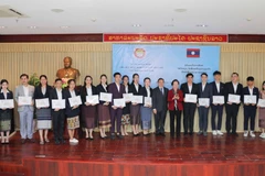 Giáo sư, tiến sỹ Nguyễn Thị Doan, nguyên Phó Chủ tịch nước, Chủ tịch Hội Khuyến học Việt Nam cùng Đại sứ Lào Sengphet Houngboungnuang trao học bổng cho sinh viên. (Ảnh: Thanh Tùng/TTXVN)