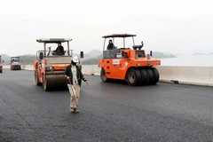 Trải thảm bêtông nhựa tuyến cao tốc Vân Đồn-Móng Cái. (Ảnh: Văn Đức/TTXVN)