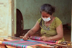 Bà Thị Nhoi ở thôn Phú Thuận, xã Phú Riềng, huyện Phú Riềng dệt thổ cẩm mỗi khi rảnh rỗi. (Ảnh: K GỬIH/TTXVN)