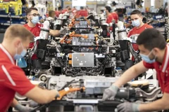 Công nhân làm việc trên dây chuyền lắp ráp xe ôtô của Hãng Porsche ở Stuttgart (Đức), ngày 12/5/2020. (Ảnh: AFP/TTXVN) 