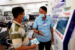 Người dân được hướng dẫn cách thức làm thủ tục hành chính theo công nghệ số tại Bộ phận một cửa thành phố Vũng Tàu. (Ảnh: Hồng Đạt/TTXVN)