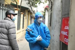 Việc sử dụng ATM Oxy là hoàn toàn miễn phí. Thành viên Tổ hỗ trợ theo dõi người nhiễm COVID-19 tại nhà phường Lĩnh Nam được trang bị đồ bảo hộ, chở oxy bằng xe máy đến tận nhà người bệnh. (Ảnh: Minh Quyết/TTXVN) 