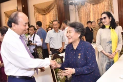 Chủ tịch nước Nguyễn Xuân Phúc giao lưu cùng các đại biểu tại buổi họp mặt. (Ảnh: Thu Hương/TTXVN) 