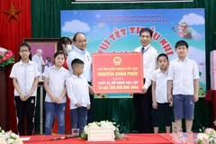 Chủ tịch nước Nguyễn Xuân Phúc tặng quà cho Trung tâm Nuôi dưỡng trẻ khuyết tật Hà Nội. (Ảnh An Đăng/TTXVN) 